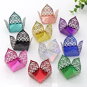Macro view of laser-cut wedding favor boxes with hollow heart patterns in multiple colors