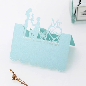 Detail of laser-cut wedding place card with 3D heart and butterfly silhouettes