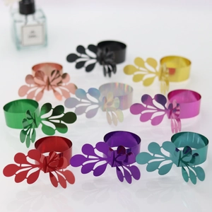 Detail showing ten multi-colored laser-cut hollow leaf napkin rings with metallic finish