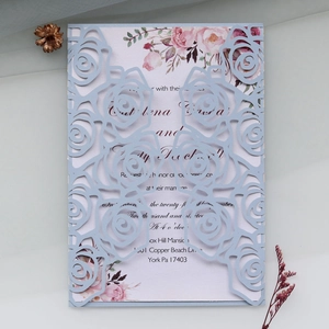 Detail of laser-cut rose hollow invitation with elegant floral insert card and light blue cover