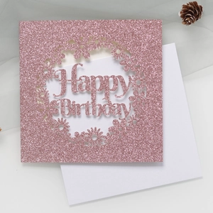 Vue détaillée d'une carte d'anniversaire pailletée or rose avec motif floral découpé au laser
