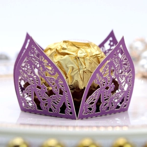 Makroansicht von lila lasergeschnittener Schokoladenhülle mit goldener Schokopraline im Detail