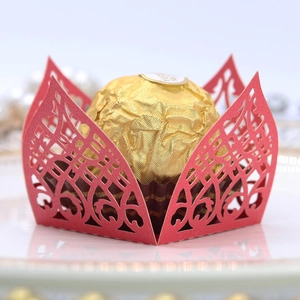 Detailed macro view of laser-cut red lace chocolate wrapper with elegant vine patterns