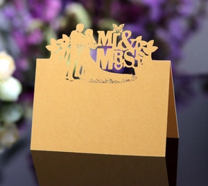 Detail of laser cut gold table card with Mr & Mrs text and butterfly design for wedding