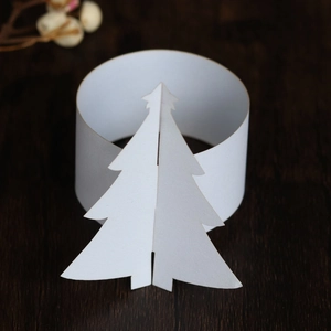 Détail du rond de serviette en papier blanc avec motif sapin de Noël 3D sur fond en bois