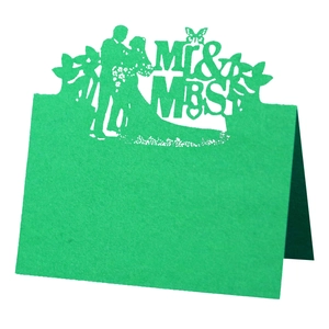 Macro detail of laser-cut Mr & Mrs green cardstock wedding place card with silhouette