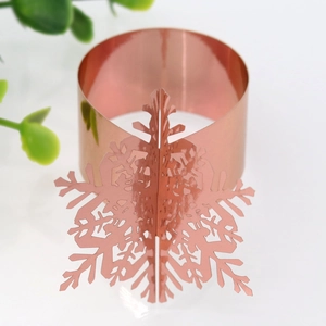 Detailed macro view of a rose gold snowflake napkin ring with a polished mirror finish