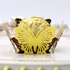 Macro view of laser-cut hollow butterfly candy box insert with gold foil chocolate
