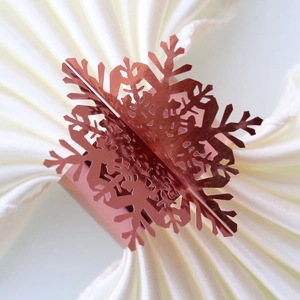Detailed close-up of rose gold snowflake napkin ring with a polished mirror finish