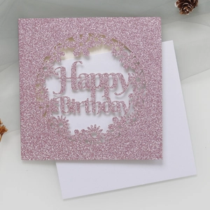 Détail d'une carte d'anniversaire rose pailletée découpée au laser avec enveloppe blanche