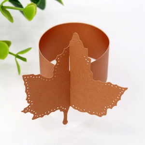 Detail of laser-cut bronze maple leaf paper napkin ring with a shimmering pearl finish
