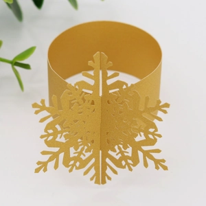 Detail of 3D golden snowflake paper napkin ring with intricate laser-cut edges