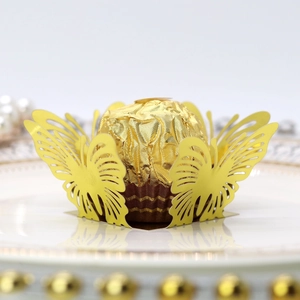 Macro shot of laser-cut gold butterfly chocolate wrapper on an elegant party table