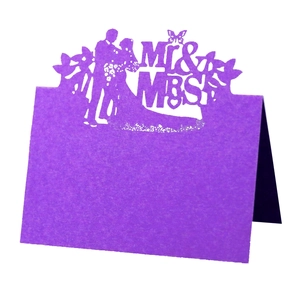 Detail of purple laser-cut Mr & Mrs wedding place card with elegant couple silhouette