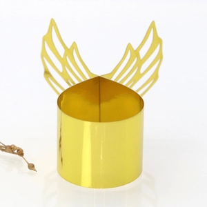 Detail of laser-cut gold angel wing napkin ring with reflective mirror finish surface