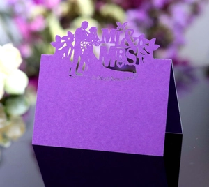 Macro detail of purple laser-cut MR & MRS wedding table card with intricate floral patterns