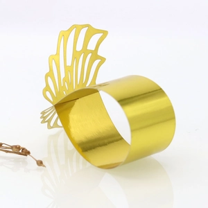 Detailed view of laser-cut gold butterfly napkin ring with intricate wing patterns