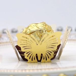 Dettaglio del pirottino per cupcake a farfalla dorata con elegante motivo intagliato