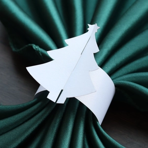 Vue macro de rond de serviette en papier sapin de Noël sur un tissu en satin vert
