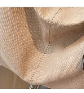 Nahaufnahme von strapazierfähigem beigem Canvas-Stoff mit hochwertigen Nähten an der Tasche
