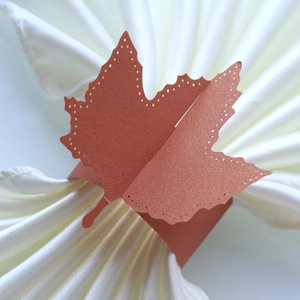 Macro shot of maple leaf paper napkin ring in metallic terracotta with laser cut details