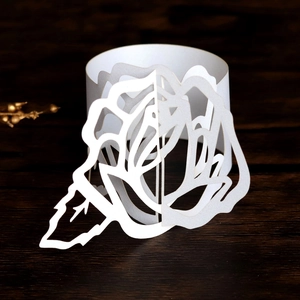 Detail of laser-cut pearl white paper napkin ring with intricate 3D rose design