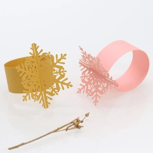 Elegant gold and pink snowflake napkin rings made of pearlescent paper for Christmas decor