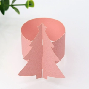 Détail d'un rond de serviette rose en papier 3D avec sapin de Noël pour décoration de table