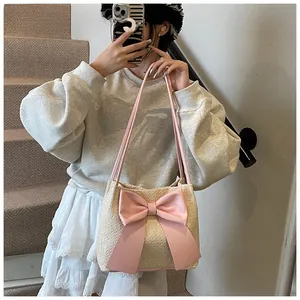 Selfie montrant la taille du sac cabas en paille beige avec un grand nœud en cuir rose