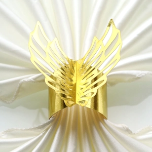Detailed close-up of a golden butterfly napkin ring with hollow carved metal wings