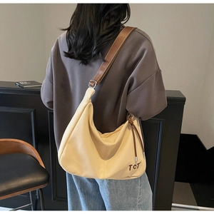 Detail einer beigen Crescent Tote Bag mit braunen Riemen und TCT-Stickerei