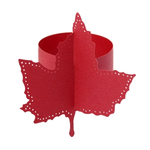 Detail shot of laser-cut red maple leaf paper napkin ring with elegant hollowed edges