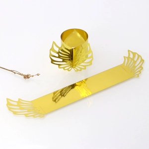 Flat lay of gold laser-cut wing napkin rings showing flat and assembled states
