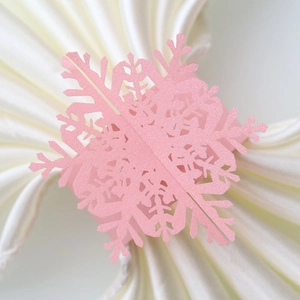 Macro detail of laser-cut pink snowflake napkin ring made of pearlescent paper