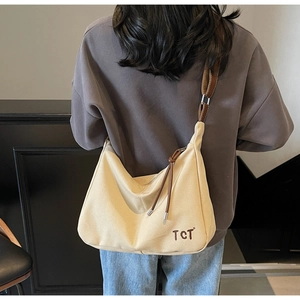 Detail der beigen Canvas-Hobo-Tasche mit großem Fassungsvermögen und Lederriemen