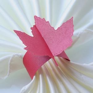 Macro detail of red glitter maple leaf napkin ring with intricate laser-cut edges