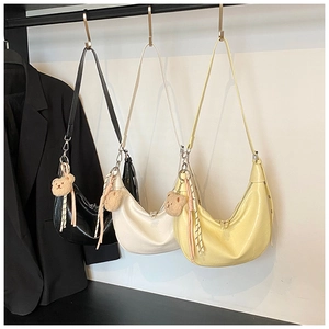 Detailed display of three hobo bags with crocodile texture and cute plush bear pendants
