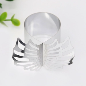 Detail of silver napkin ring with laser-cut butterfly wing pattern and metallic finish