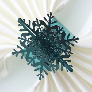 Detail showing the laser-cut hollow snowflake napkin ring in deep green pearlescent paper