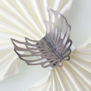 Detailed macro view of silver hollow butterfly napkin ring on a satin napkin
