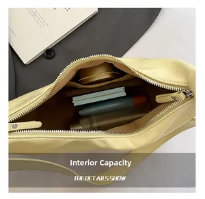 Macro view of creamy yellow croc-effect handbag interior with daily cosmetics