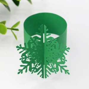 Macro detail of a 3D forest green snowflake laser-cut paper napkin ring for table decor