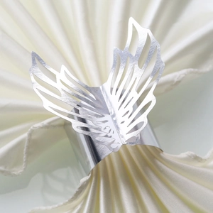 Close-up of elegant silver hollow butterfly wing napkin ring for wedding table decor