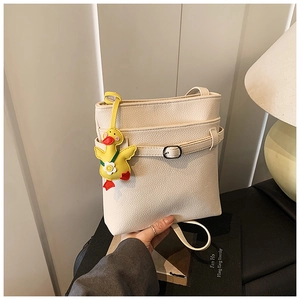 Détail du sac seau blanc cassé avec texture litchi et un adorable canard en peluche