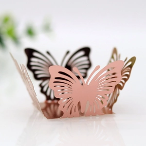 Close-up of pink laser-cut butterfly hollow cupcake wrapper with a metallic finish