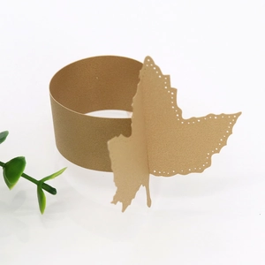 Detailed view of laser-cut butterfly champagne gold paper napkin ring with pearl finish