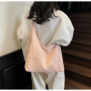 Pink large capacity hobo bag worn by model showing casual slouchy design on shoulder