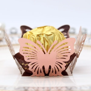 Detailed laser-cut butterfly cupcake wrapper in dusty pink for wedding chocolate decor
