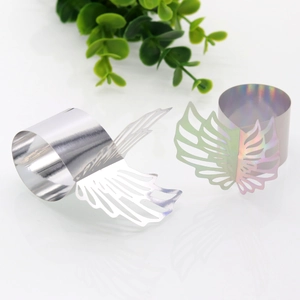 Detailed view of hollow angel wing napkin rings in silver and holographic finishes