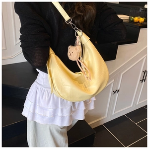 Pale yellow crescent dumpling bag with crocodile texture and brown bear pendant